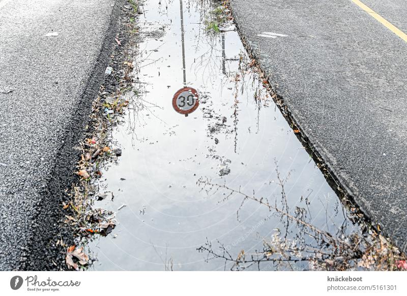 tempo 30 Pfütze Straße Reflexion & Spiegelung Außenaufnahme Wasser Asphalt Pfützenspiegelung Geschwindigkeitsbegrenzung Tempo 30 tempolimit Verkehrswege