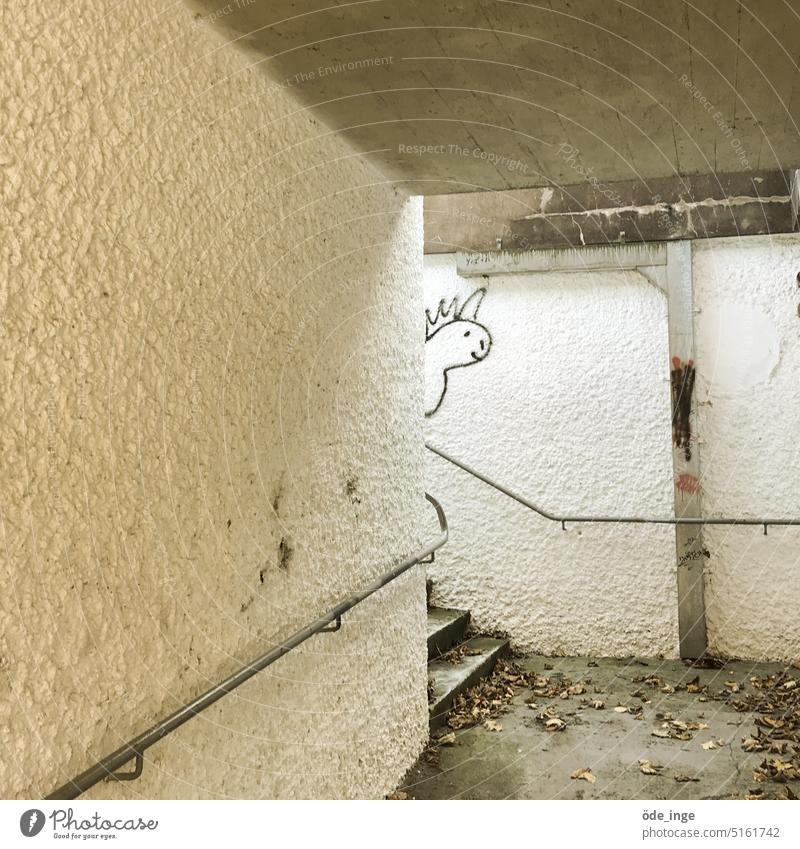 scheues Einhorn im Untergrund Graffiti Tunnel Wand Unterführung Geländer laub Schmiererei Treppe Beton süß Drache Kunst trist Stadt Treppengeländer Fabelwesen