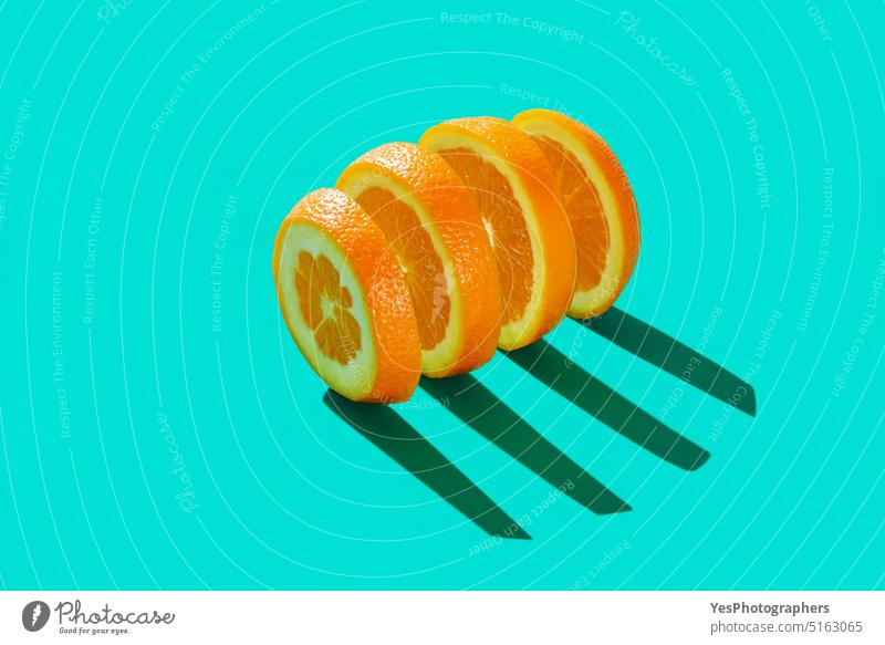 Geschnittene Orange isoliert auf einem blauen cyanfarbenen Hintergrund abstrakt hell Zitrusfrüchte Nahaufnahme Farbe farbenfroh Konzept Textfreiraum kreativ