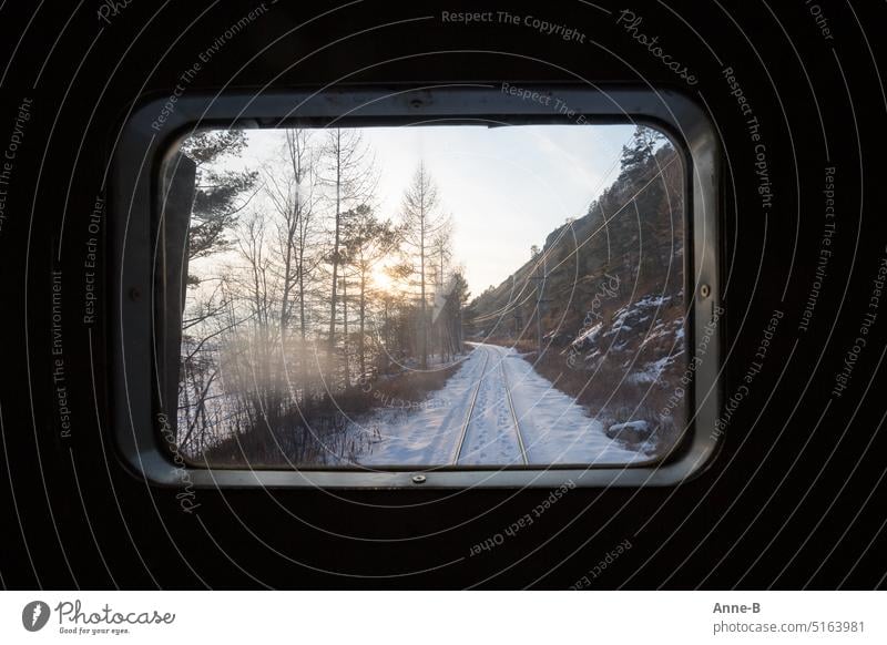 Blick aus dem allerletzten Fenster der Baikalbahn auf eine verschneite Landschaft mit Fußspuren im Schnee zwischen den Gleisen, die Schaffnerin hat den Zug mit Holz und Kohlen geheizt. Er war sehr warm.