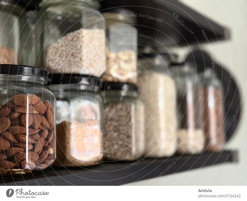 gefüllte Vorratsgläser im Regal Gefäß Küche Frühstück Mandeln Müsli Ceralien Superfood nachhaltig unverpackt bio öko Laden einkaufen konsum Lebensmittel