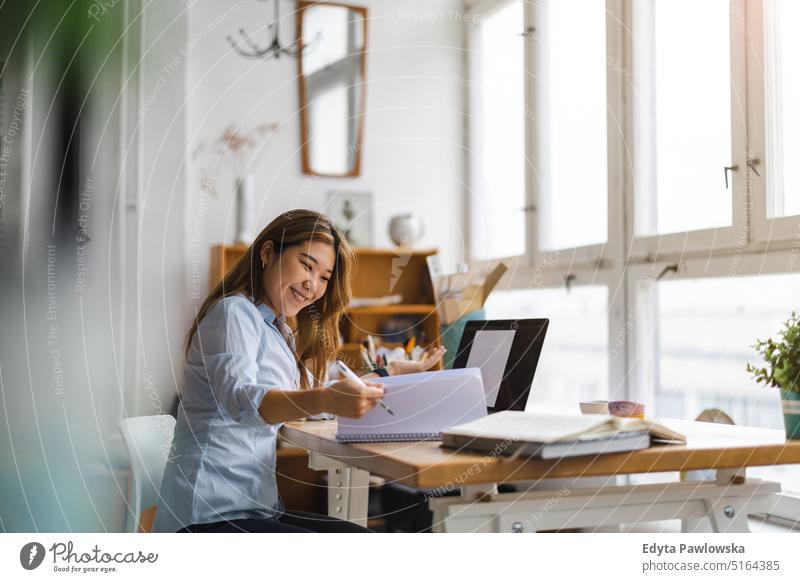 Junge Frau sitzt am Schreibtisch und arbeitet am Laptop echte Menschen Jahrtausende Schüler im Innenbereich Loft Fenster natürlich Mädchen Erwachsener eine