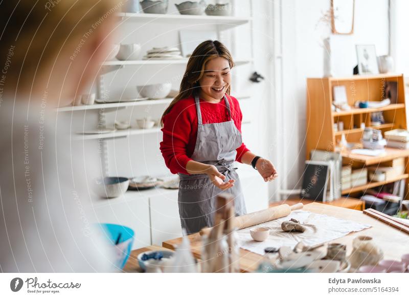 Junge Frau bei der Arbeit in einer Töpferwerkstatt Töpferwaren Künstler Kunst Keramik Handwerk Handwerker Hobbys Werkstatt Ton handgemacht professionell