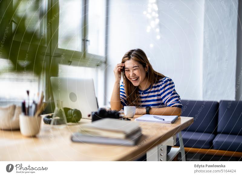 Junge Frau sitzt am Schreibtisch und arbeitet am Laptop echte Menschen Jahrtausende Schüler im Innenbereich Loft Fenster natürlich Mädchen Erwachsener eine