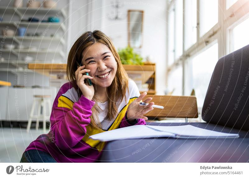 Junge Frau benutzt Smartphone im Loftbüro echte Menschen Jahrtausende Schüler im Innenbereich Fenster natürlich Mädchen Erwachsener eine attraktiv gelungen