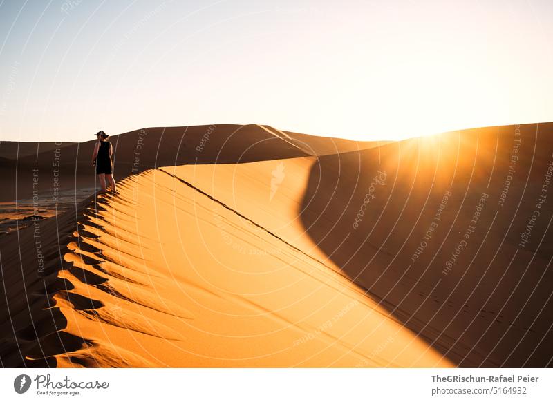 Sonnenuntergang auf Düne mit Mensch auf Dünenrand Sand Namibia Afrika reisen Wüste Landschaft Abenteuer Natur Wärme Sossusvlei Ferne Schatten Licht