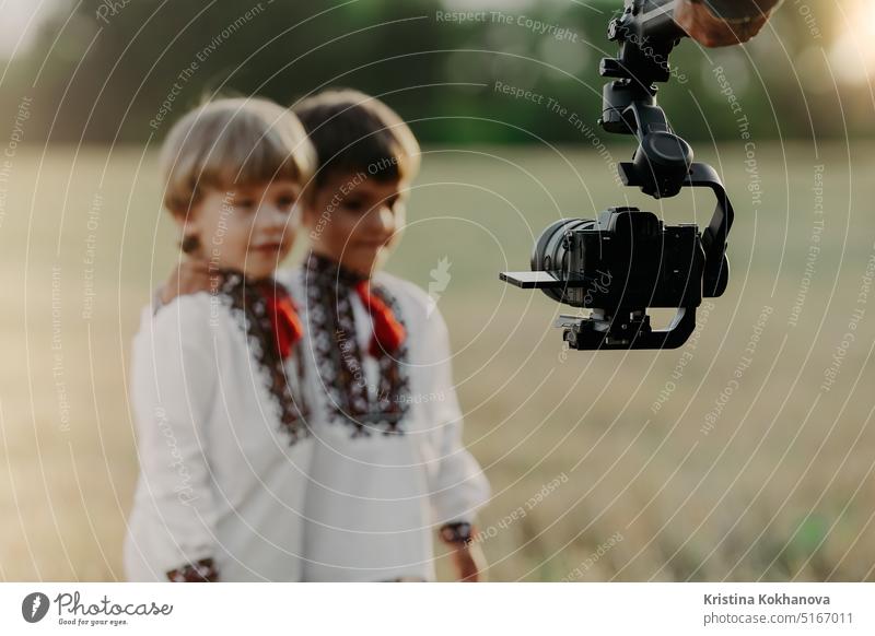 Videokamera auf Stabilisator, Mann arbeitet mit Kindern, professionelle Ausrüstung Fotokamera Kameramann Gerät Filmmaterial Medien Betreiber Fernsehen