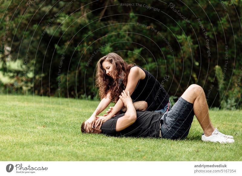 junges paar hat spaß und spielt auf dem gras an einem sommertag. frau liegt über ihrem liebhaber, lächelnd Spaß Park Paar Tag niedlich sonnig habend Lifestyle