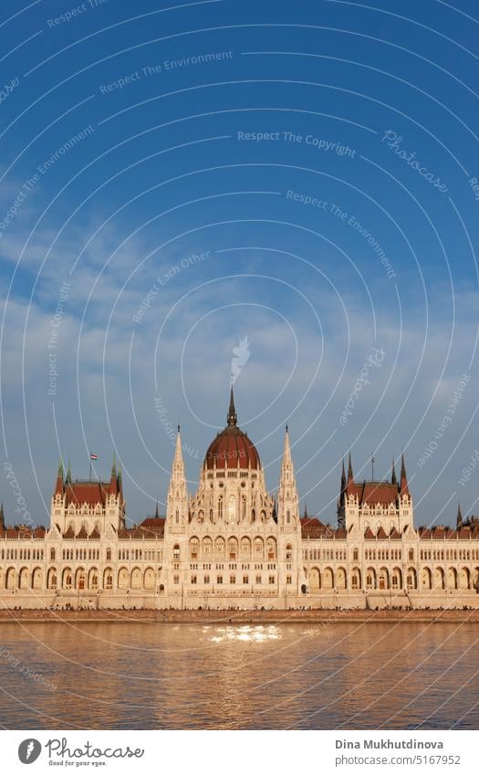 Ungarisches Parlamentsgebäude in Budapest, das sich im Wasser der Donau spiegelt, fotografiert an einem sonnigen Tag mit blauem Himmel. Domed neugotischen Stil Architektur. Berühmte Wahrzeichen für Sightseeing in Ungarn Postkartenansicht.