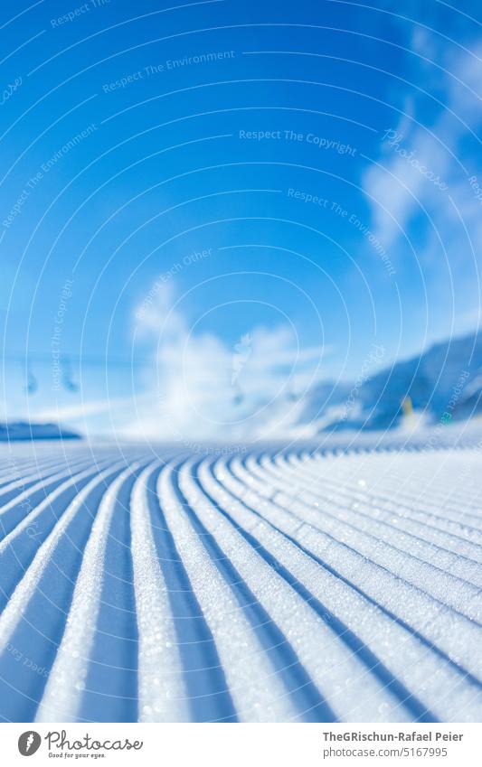Frische Piste mit Sessellift im Hintergrund vor blauem Himmel Schnee Loipe sessellift Skigebiet Blauer Himmel kalt Muster Winter Wintersport Skifahren