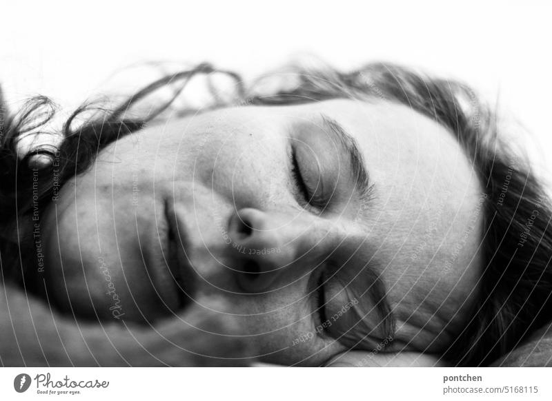 der kopf einer schlafenden frau in seitenlage. weibliches gesicht. schwarz-weiß liegen friedlich Erholung Müdigkeit träumen geschlossene Augen Porträt