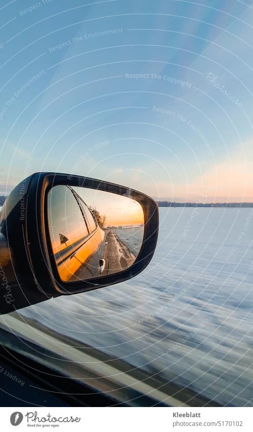 Außenspiegelfoto - Sonnenaufgang im Winter bei schneller Fahrt - Momentaufnahme Aussenspiegel Auto Jahreszeit Schnee blauer Himmel Textfreiraum vorbeiziehend