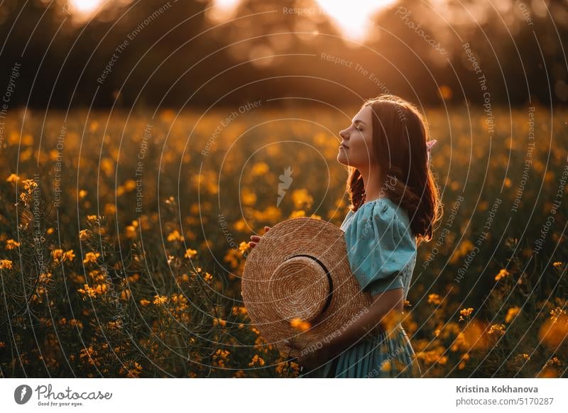 Glückliche Frau in blühendem Rapsfeld. Dame im Retro-Kleid, Frühlingssaison landwirtschaftlich Hintergrund schön Schönheit blond Blütezeit hell Rapsblüten