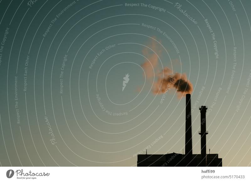 Schornstein einer Fabrik mit Rauch, Dampf, Emission vor blauem, wolkenlosem Himmel bei Sonnenuntergang dampf Umweltverschmutzung Klimawandel CO2-Ausstoß
