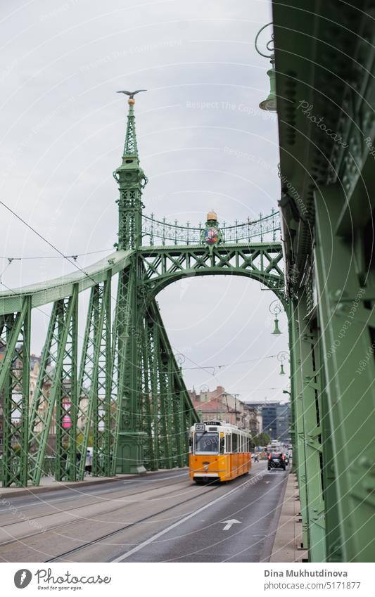 Gelbe Straßenbahn fährt über die berühmte grüne Freiheitsbrücke in Budapest, Ungarn. Historisches Wahrzeichen. Brücke Tourismus Transport Landschaft Stein urban