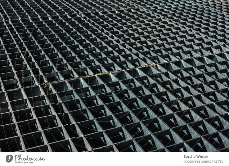 Bildfüllende Aufnahme eines Schwerlast-Metallgitters als befahrbare Abdeckung einer Gießmulde Reflexion & Spiegelung metallisch Architektur Stahlgitterrost
