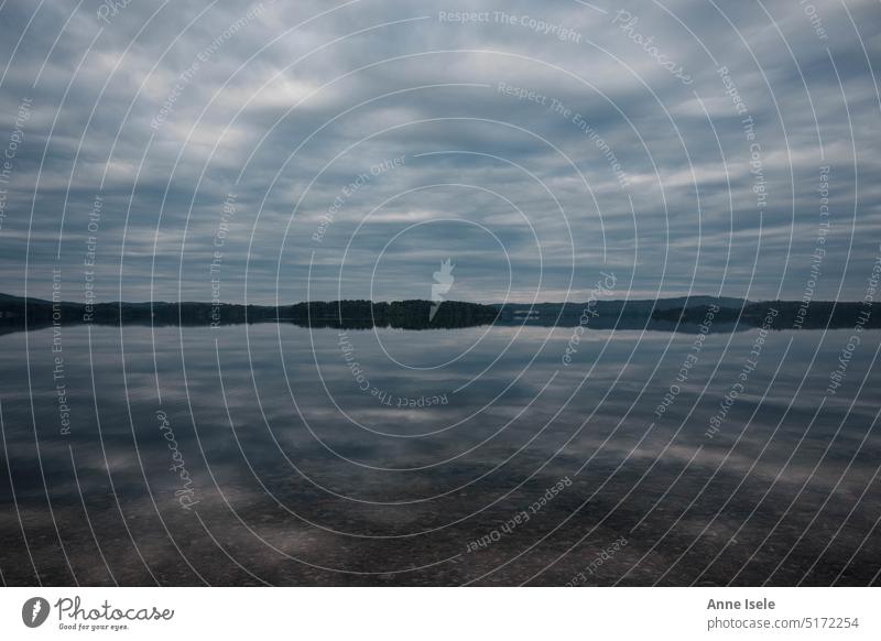 Ein spiegelglatter See in Schweden, der Himmel spiegelt sich im Wasser Spiegelung wolkig Reflexion & Spiegelung Ruhe Einsamkeit stille Ferne ufer Wald