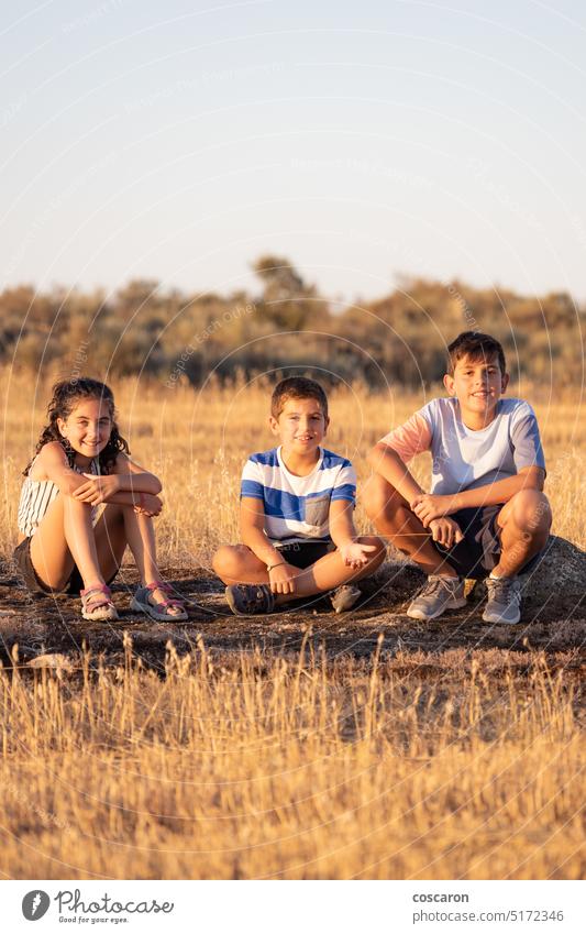Drei Kinder sitzen in ihren Sommerferien auf einem Felsen aktiv Abenteuer blau Junge Lager Kindheit Klettern trocknen erkunden Familie Feld Wald Mädchen