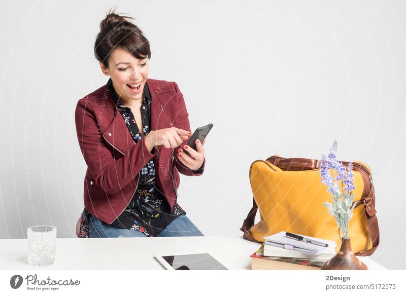 Geschäftsfrau mit Telefon und Tablet auf dem Schreibtisch sitzend am heimischen Arbeitsplatz, Person Frau Pferdeschwanz Tablette Technik & Technologie online
