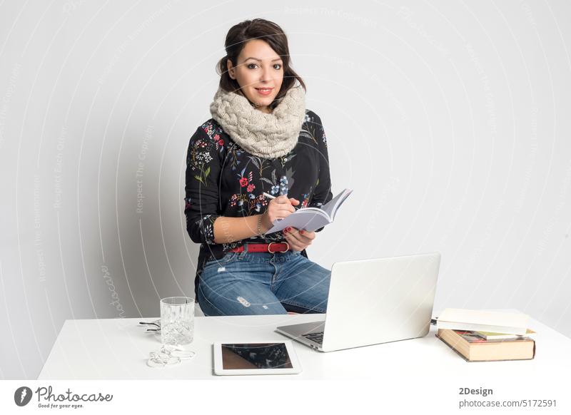 Lächelnder Modedesigner, der auf einem Notizbuch schreibt Person Frau Atelier Stehen Notebook vereinzelt Erwachsener Buch Model Business Porträt jung