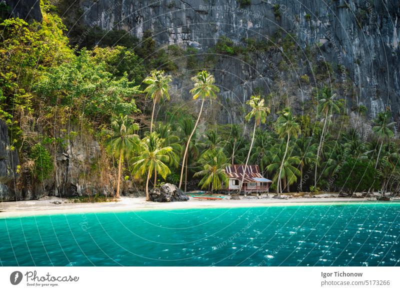Abgelegener Strand mit Hütte unter Palmen auf der Insel Pinagbuyutan. Erstaunliche Kalksteinfelsen, Sandstrand, türkisblaues Lagunenwasser Philippinen palawan