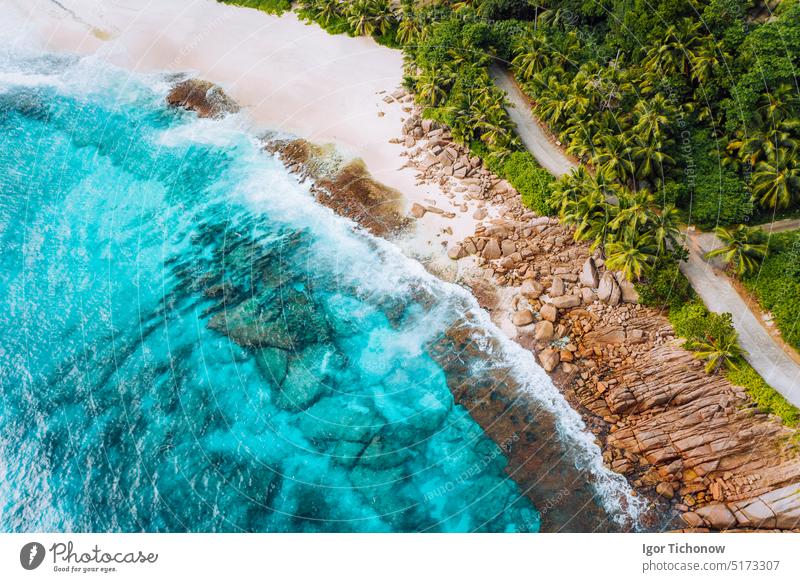 Luftaufnahme von Ozeanwellen, die auf die felsige Küste des schönen paradiesischen Traumstrandes auf den Seychellen treffen. Sommerurlaub, Reisen und Lifestyle-Konzept