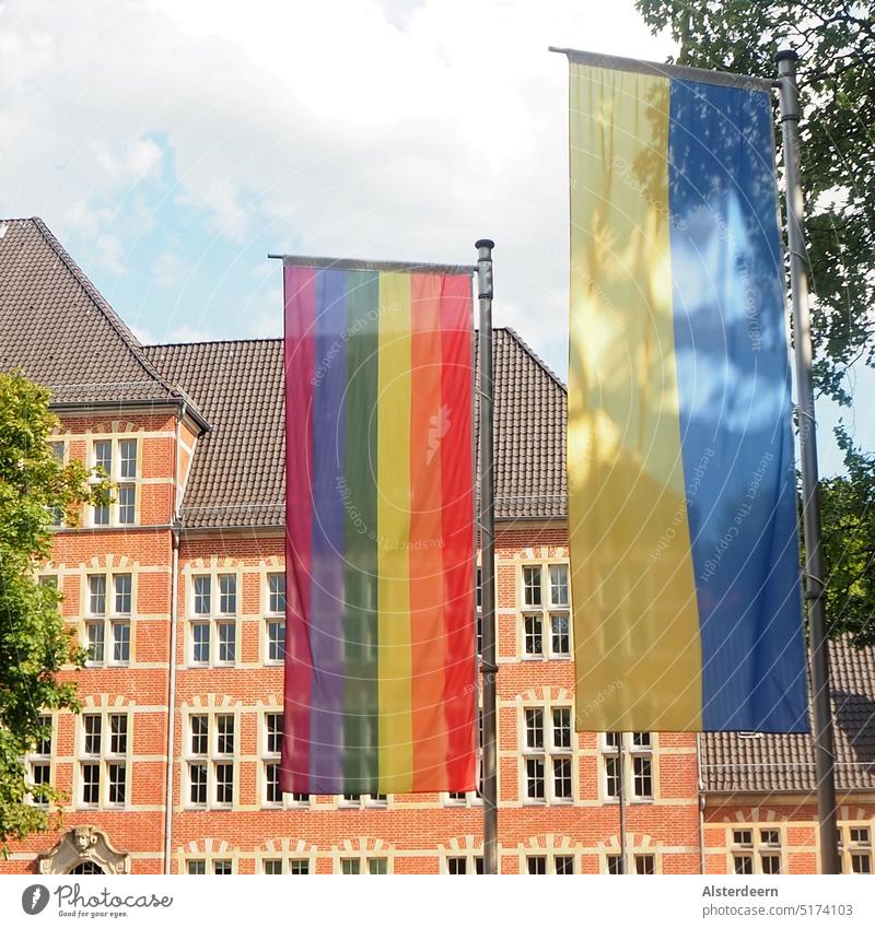 Regenbogen und Ukraine Flagge nebeneinander vor altem Gebäude in Hamburg vertikal am Flaggenmast altes Gebäude Hansestadt hoch Hochformat Fahne Regenbogenfahne