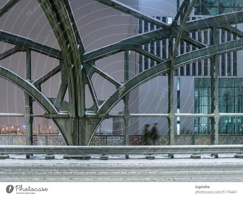 Nachtspaziergang im Winter, über eine Eisenbahnbrücke mystisch Licht Stadt Schnee Spaziergänger Paar Straße Eisenkonstruktion blaugrün Schneefall München