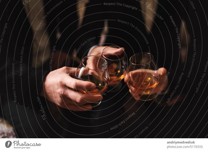 Geschäftstreffen. Männer halten Gläser mit Whiskey. Männerparty. Hand mit einem Getränk von Alkohol Party Röstung Whisky Freunde Schottisch Menschen Brille