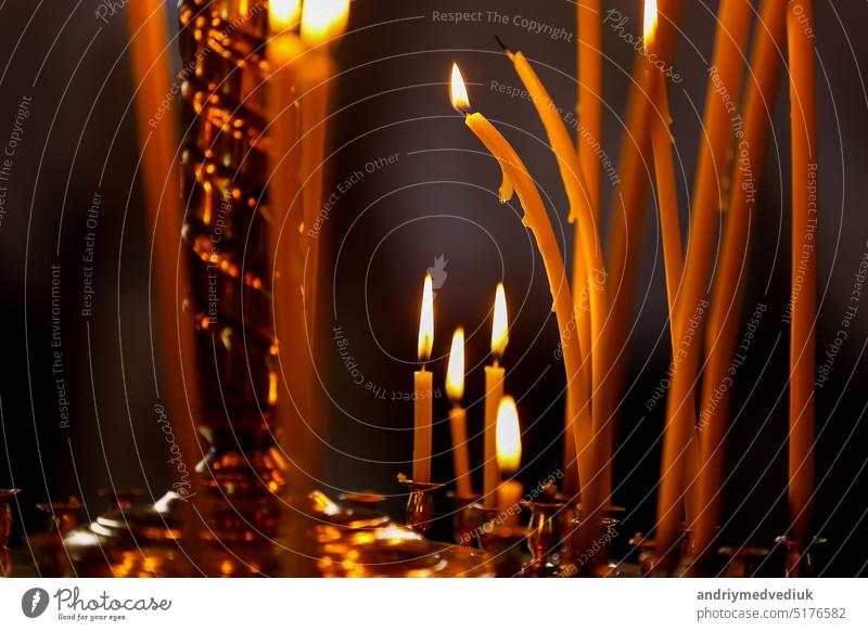 letzte Kerze brennen in einer orthodoxen Kirche. Kirche Kerze brennen auf einem großen goldenen Leuchter in der Kirche. Viele brennende Wachskerzen in der orthodoxen Kirche. selektiver Fokus