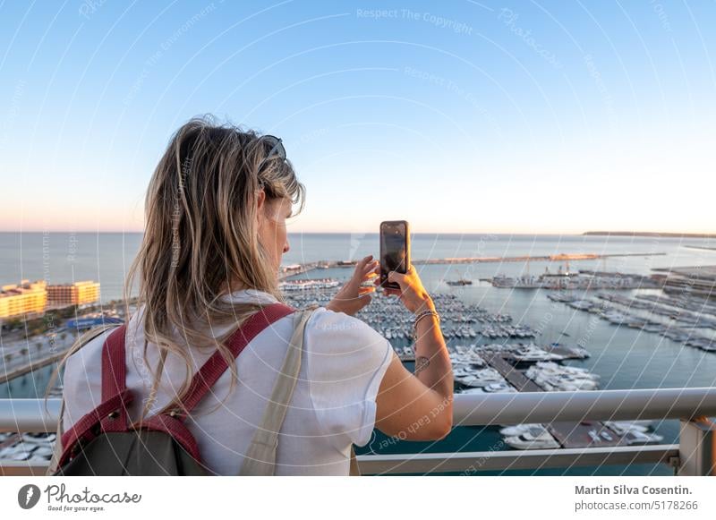Frau fotografiert den Hafen von Alicante von einer Hotelterrasse in Spanien aus Erwachsener Alacant alicante Architektur Strand schön blau Fotokamera lässig