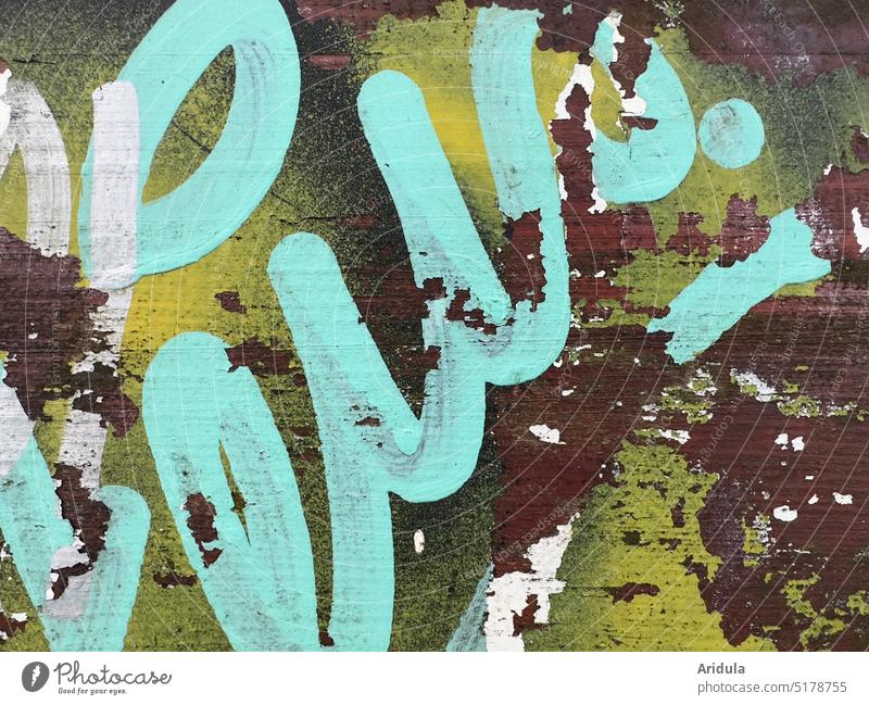 Verwittertes Graffiti auf Holzbank Schrift Struktur Gestaltung Zerstörung Buchstaben Typographie Menschenleer türkis gelb rotbraun Schriftzeichen Text Zeichen