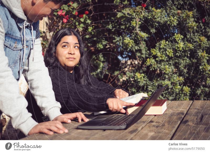 zwei junge Männer lernen vor der Schule mit Laptops lateinamerikanerin wütend Bücher Freund brüderlich Brüder kollaborierend gemeinsames Konzept Textfreiraum