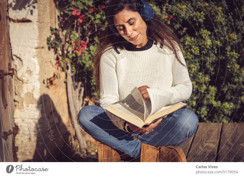 Frau draußen blättert in einem Buch, das sie liest 40s 50s lateinamerikanerin allein schön Bestseller Stiefel bequem Textfreiraum Genuss kurzweilig Frauen