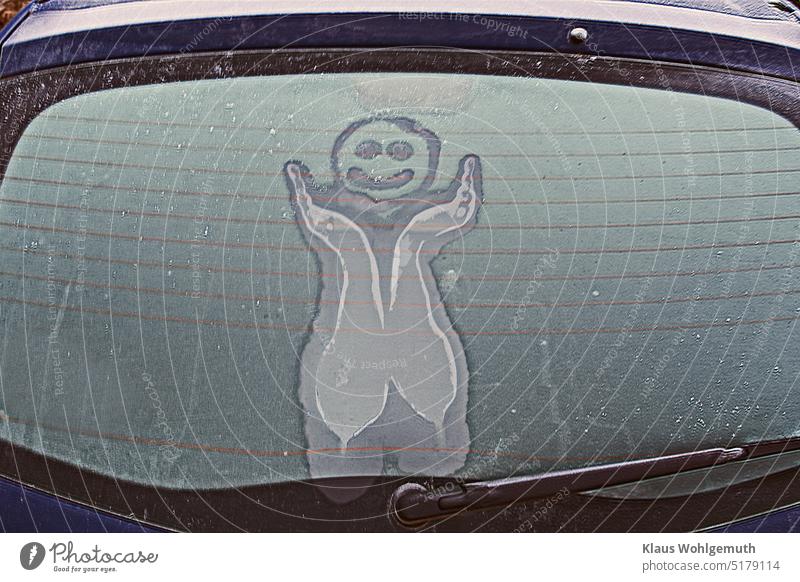 Lustige Figur auf der vereisten Heckscheibe eines Autos Smiley Heckscheibenheizung Winter Karikatur Zeichnung Eis Frost Scheibenwischer Autoscheibe