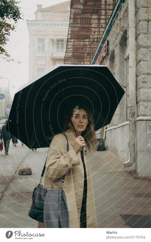 "Überrumpeltes" Mädchen mit schwarzem Regenschirm im Nebel Überraschung Frau Porträt hübsch jung Lifestyle Nebellandschaft Großstadt Stadtbild Gebäude