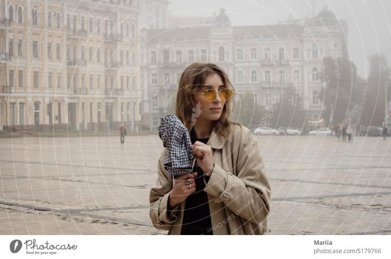 Mädchen mit gelber Brille im Nebel hübsche Frau Gelbe Brille Großstadt Stadtbild Regenschirm jung Erwachsener Porträt Stadtplatz Quadrat Architektur besinnlich