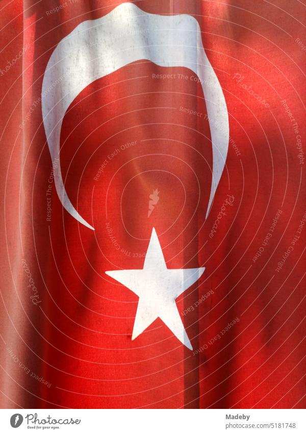 Rote türkische Fahne mit weißem Stern im Sommer bei Sonnenschein an einem Hauseingang in Inkumu am Schwarzen Meer in der Provinz Bartin in der Türkei türkei