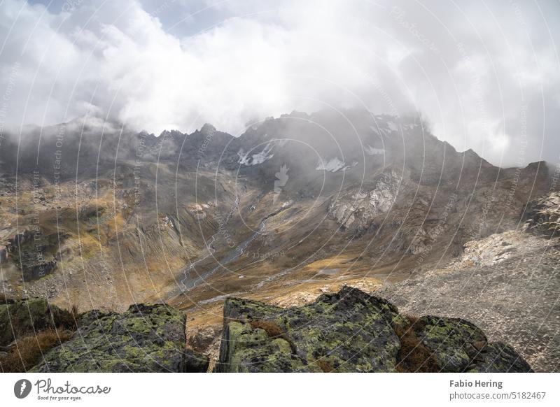 Berggipfel in den Alpen unter Wolkendecke mit Felsen im Vordergrund Berge u. Gebirge Gipfel Landschaft Natur Schneebedeckte Gipfel Menschenleer Farbfoto Umwelt