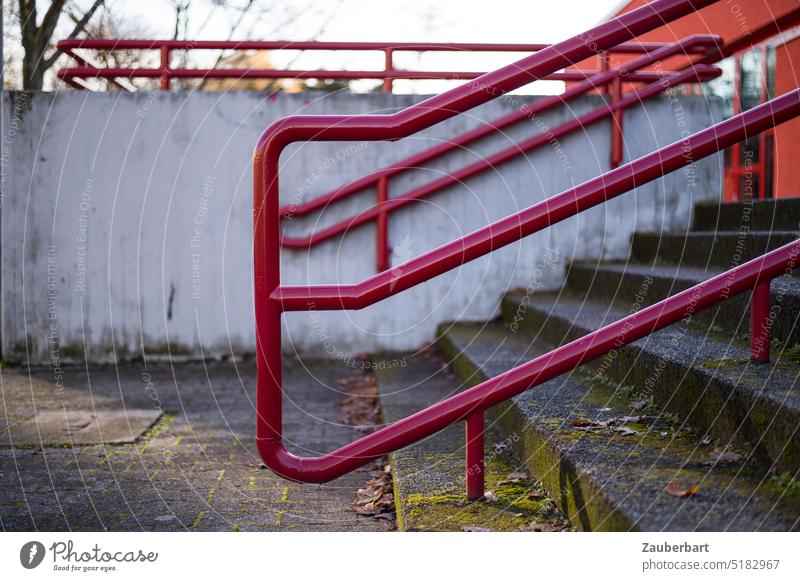Rotes Treppengeländer vor Betonwand, Architektur der 70er Jahre Geländer rot Struktur Waschbeton Aufgang Aufstieg Abstieg Rohre architektonisch