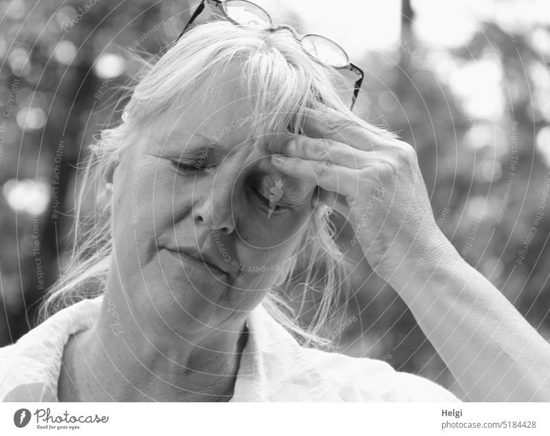Kopfweh - Porträt einer Frau, die sich bei geschlossenen Augen mit der Hand an die Stirn fasst Mensch Seniorin Kopfschmerzen Schmerzen Gesicht Arm