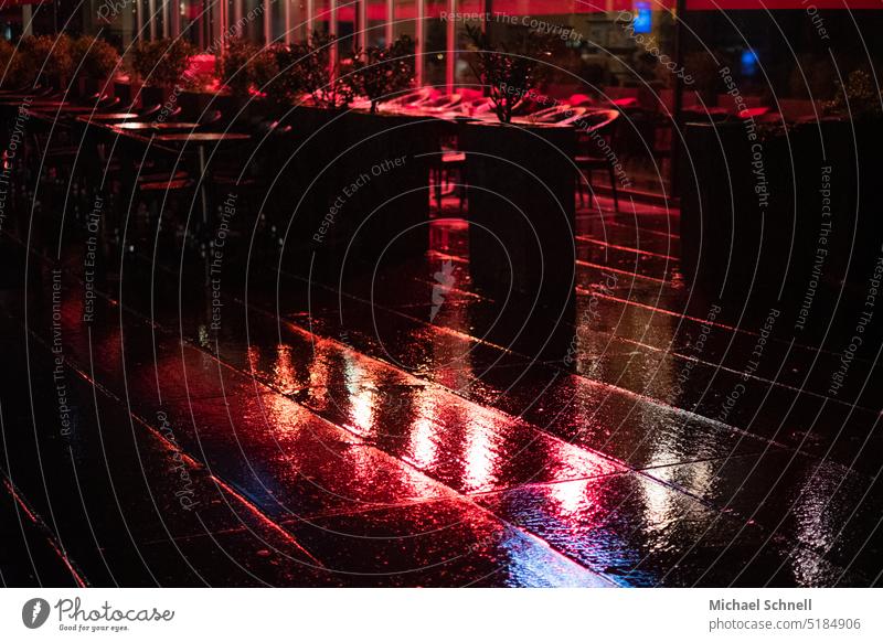 Straßencafé am Abend im Regen Café nass Wasser Wassertropfen Gastronomie Tisch leer Stuhl Restaurant Menschenleer Außenaufnahme Terrasse rot regnerisch