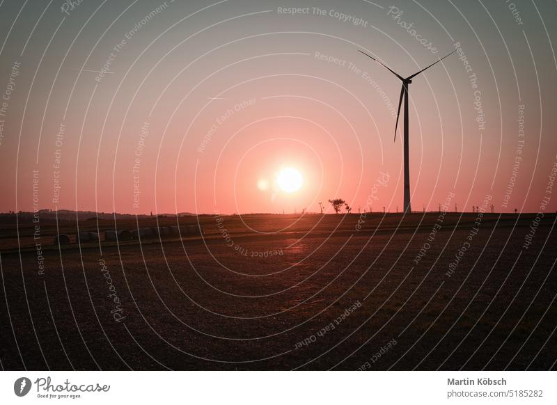 Onshore-Windkraftanlage auf einer Wiese bei Sonnenuntergang. Erneuerbare Energie. Sauberer Strom an Land saubere Energie zweite Änderung Netzbetreiber