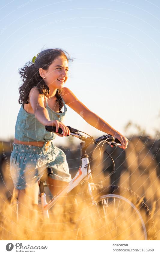 Nettes Mädchen mit ihrem Fahrrad im Sommer. aktiv Schönheit Radfahren Blauer Himmel Kaukasier Kind Landschaft Zyklus Fahrradfahren Radfahrer trocknen Frau Feld