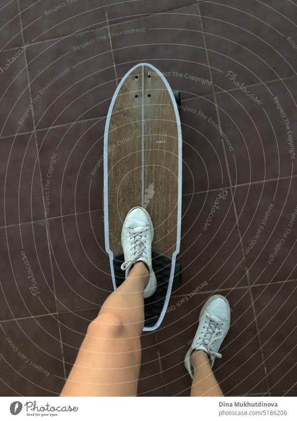 Mädchen skateboarding in weißen Turnschuhen. Beine in alten Lederschuhen auf einem Holzskateboard. Schlittschuhlaufen Skateboard jung Bekleidung Aktivität Frau