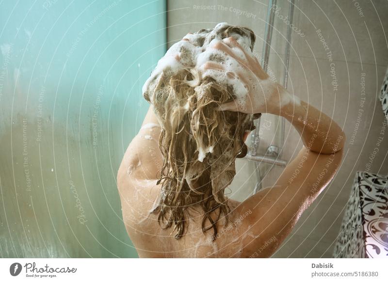Rückansicht einer Frau beim Duschen im Badezimmer nehmen Rücken Behaarung Hygiene Körper Kopf Sauberkeit Kabine unter Haarwaschmittel Wäsche waschen offen