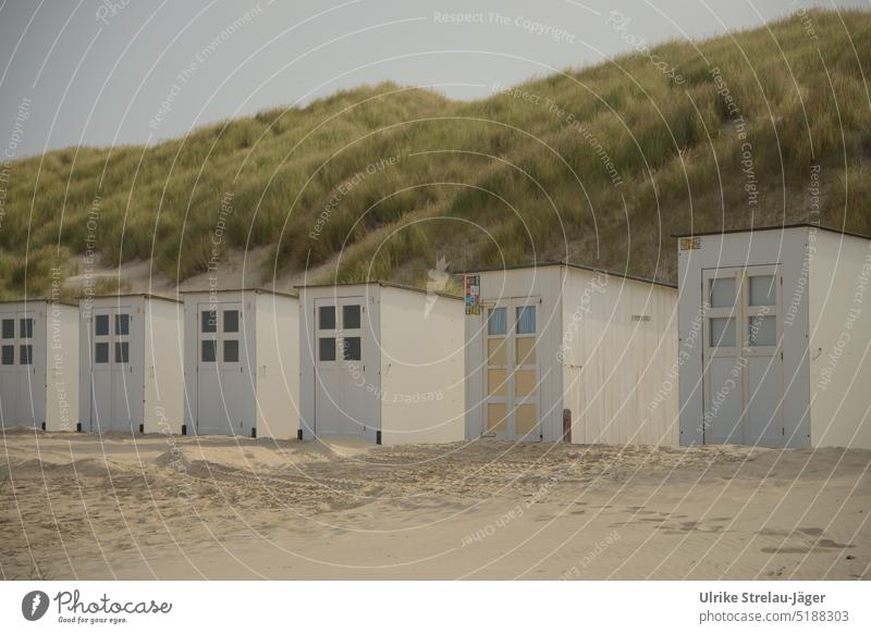 Strandhütten weiss und alternativ mit gelber und hellblauer Tür an Dünen Holzhütte weiße Strandhütte gelbe Holztür Sandstrand umweht verweht Hütte Sanddünen