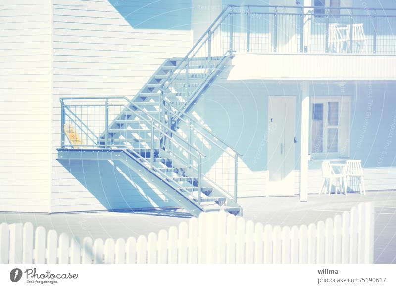 weißes Holzhaus mit Außentreppe Treppe pastell Villa Zaun 50iger Jahre Style Haus schlicht sonnig Menschenleer Treppengeländer sauber sommerlich hell Apartment