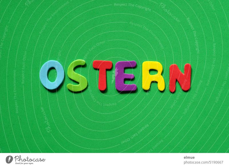 OSTERN  steht in farbigen Buchstaben auf grünem Untergrund Ostern bunt Osterdeko Abstraktion Illustration Osterkarte Flatlay Deko Moosgummi Frohe Ostern