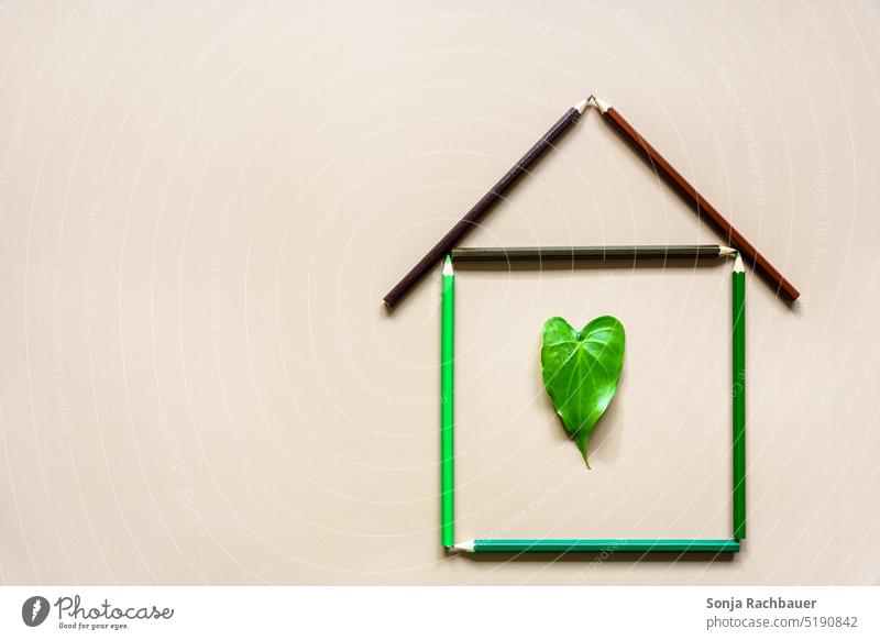Ein Haus aus Buntstiften mit einem grünen Blatt in Herzform Kreativität hauskauf Symbole & Metaphern herzförmig Zeichen Draufsicht Umwelt